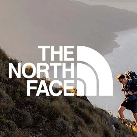 The North Face logo with a hiker on a mountain ridge in the background