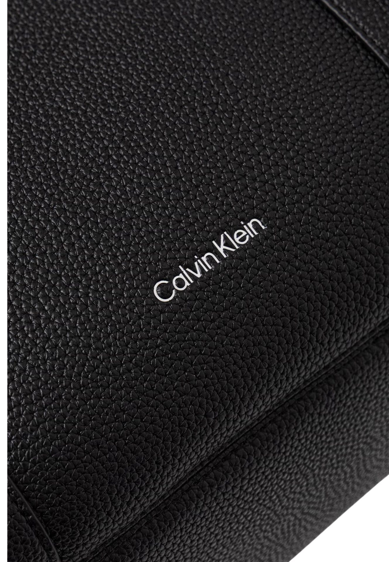 Close-up of black pebbled leather with the Calvin Klein logo in white