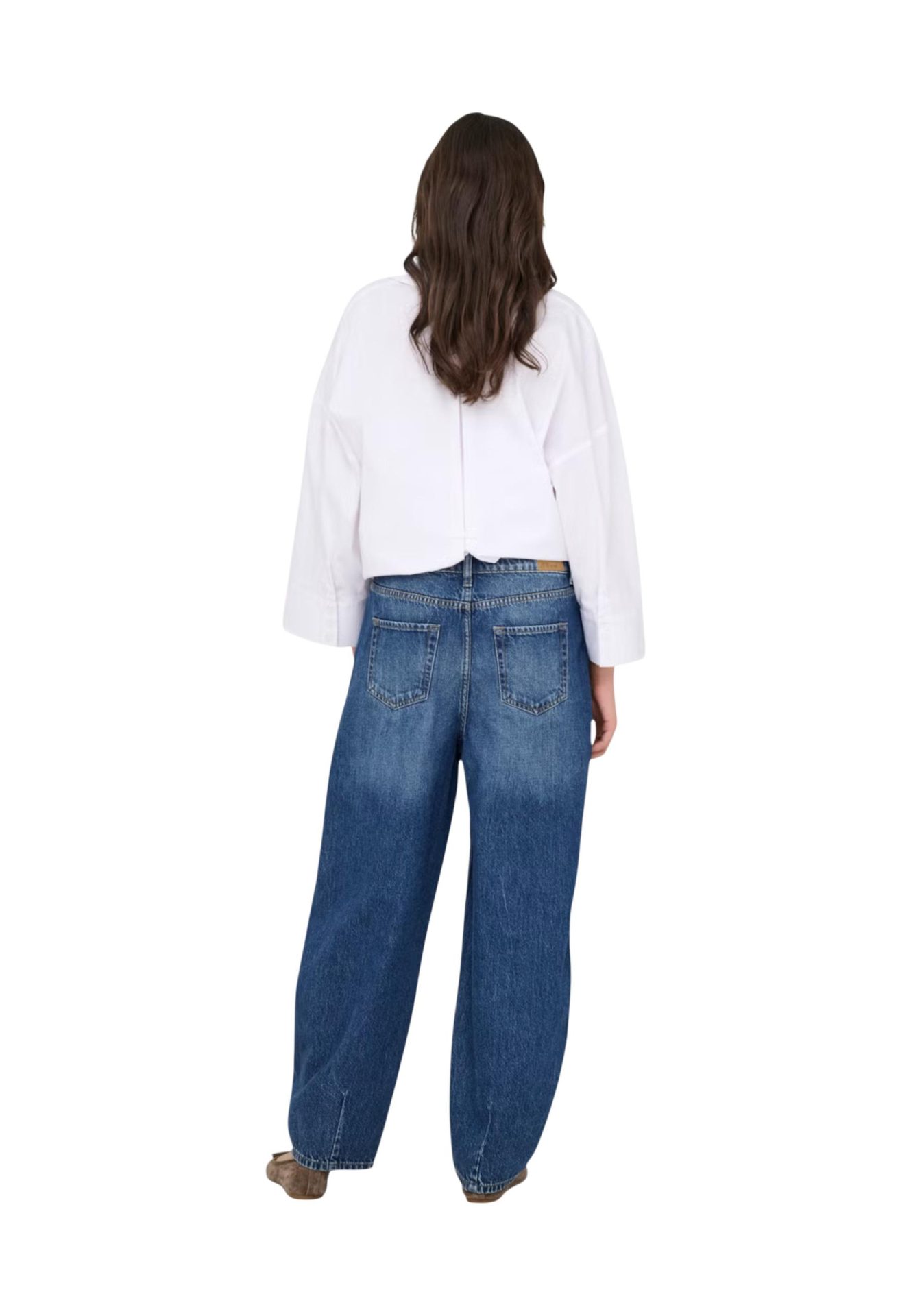 Back view of a person wearing wide-leg blue jeans and a white long-sleeve shirt