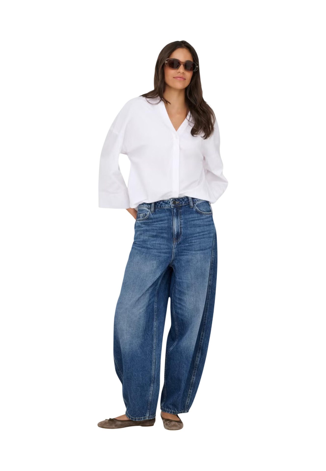 Woman wearing a white long-sleeve button-down shirt and wide-leg blue jeans