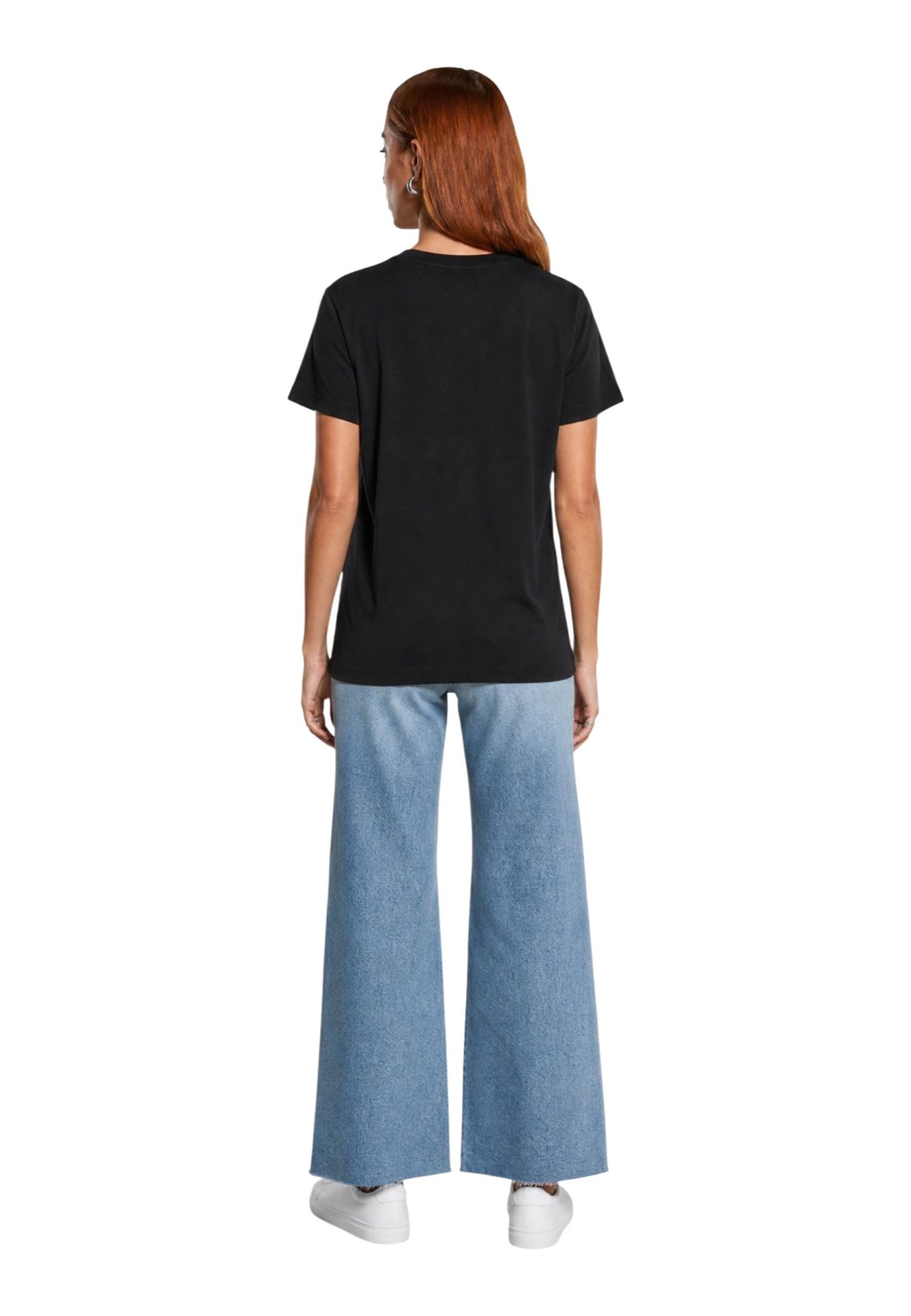 Back view of a model wearing a black t-shirt and light blue wide-leg jeans