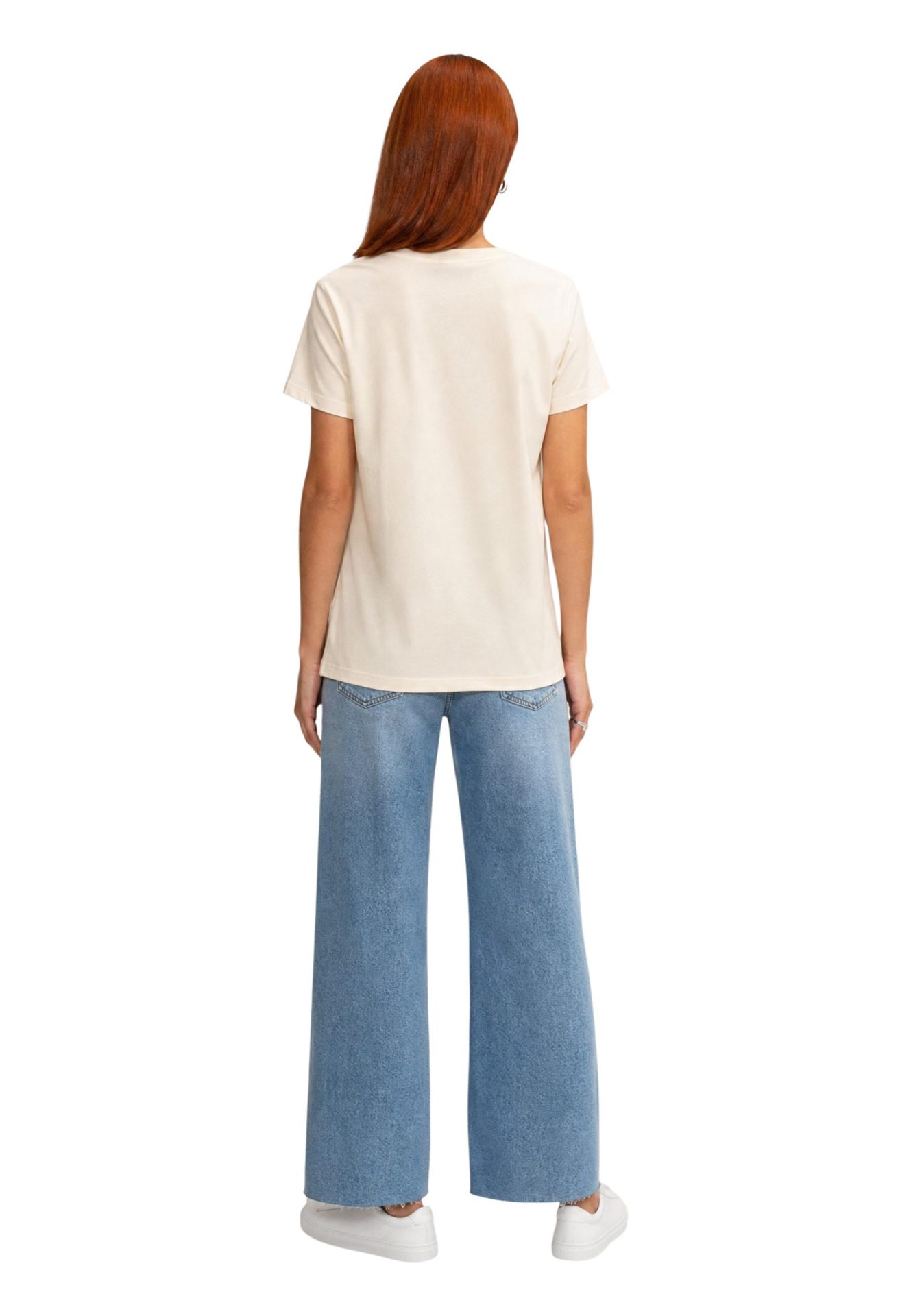 Back view of a woman wearing a cream t-shirt and light blue wide-leg jeans